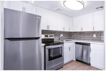 A modern kitchen with a stainless steel refrigerator and oven.